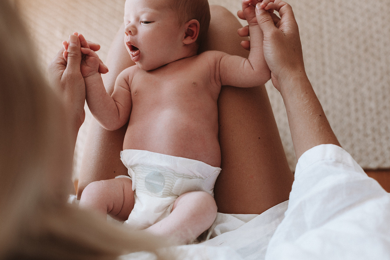 baby on mother's lap with Ecoriginals diapers