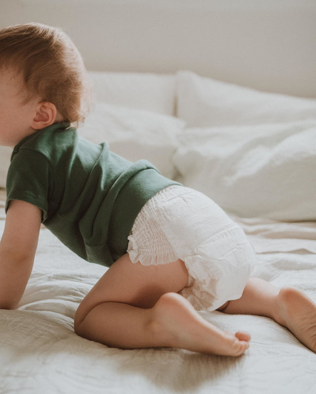 baby crawling on bed with ecoriginals diapers